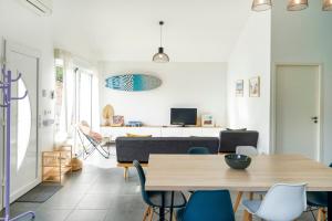 a living room with a table and chairs at Maison Cosy avec Piscine in Tarnos