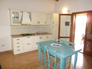 a kitchen with a blue table and chairs at Le Villette di San Teodoro in San Teodoro +32 photos