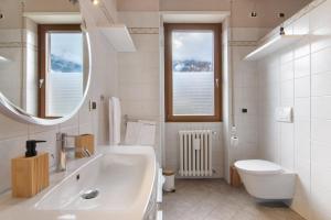 a white bathroom with a sink and a toilet at Como Lake Home in Colico +35 photos