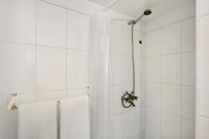 a white bathroom with a shower with white towels at casa Jardín del sol planta baja in Tacoronte +15 photos