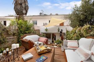 a patio with couches and a table and a house at casa Jardín del sol planta baja in Tacoronte
