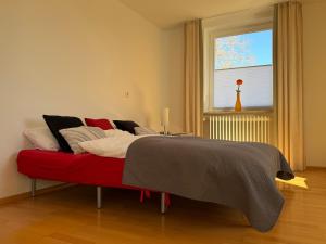 a bed in a room with a red couch at Ferienwohnung Sieglinde in Bad Dürrheim +29 photos