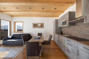 a kitchen and living room with a table and a couch at Ferienwohnung 2 Weger in Andrian +19 photos