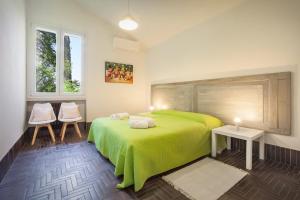 a bedroom with a green bed and two chairs at Villa Brancolino - Fine Living in Garda