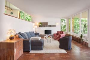a living room with a blue couch and chairs at Villa Brancolino - Fine Living in Garda