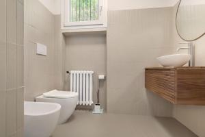 a bathroom with a toilet and a sink and a mirror at Villa Brancolino - Fine Living in Garda +16 photos