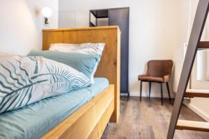 a bed with a wooden headboard and a chair in a room at Ferienwohnung Jost in Sundern
