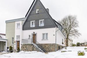 a white house with a gambrel roof at Ferienwohnung Jost in Sundern