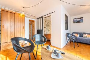 a living room with black chairs and a table at Maison traditionnelle au centre in Les Sables-d'Olonne