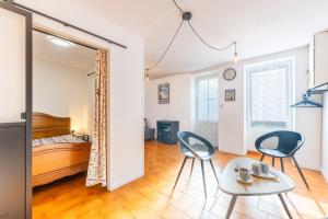 a room with two chairs and a table and a bed at Maison traditionnelle au centre in Les Sables-d'Olonne
