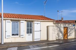 a white building with white doors and a street at Maison traditionnelle au centre in Les Sables-d'Olonne