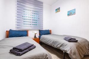 two beds in a room with blue pillows on them at Quintana's Home Oropesa Del Mar in El Borseral +19 photos