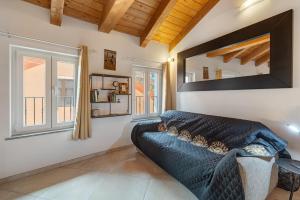a living room with a couch and two windows at Maison Nature e Relax Rubino in Osiglia