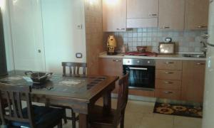 una cucina con un tavolo di legno e un tavolo e sedie di Portico dei Sassi a Matera