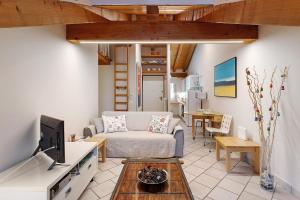 a living room with a couch and a tv at Il Nido Aosta in Aosta