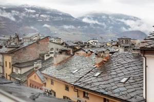 a view of roofs of buildings with mountains in the background at Il Nido Aosta in Aosta