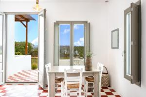a white dining room with a table and chairs at Luna Rossa Milos - Cocoon in Provatas
