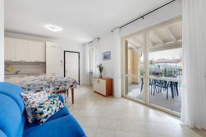 a living room with a blue couch and a table at Everlakegarda in Desenzano del Garda