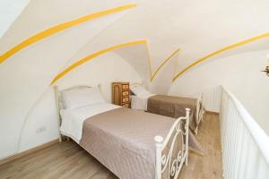 two beds in a room with an attic at Matinè Suite And Room in Matino
