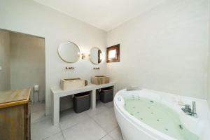 a bathroom with a tub and a sink and mirror at Matinè Suite And Room in Matino +17 photos