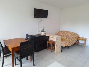 a living room with a table and a desk and a chair at Au calme avec balcon proche Genève in Gaillard