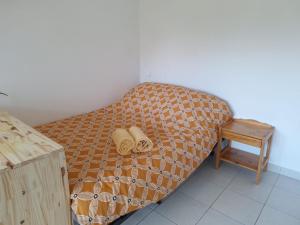 a bed with two pillows on it next to a table at Au calme avec balcon proche Genève in Gaillard