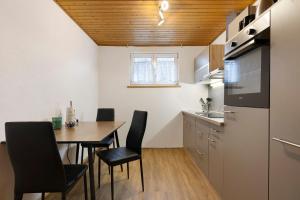 a kitchen and dining room with a table and chairs at Apartments Winder 3 in Lustenau +18 photos