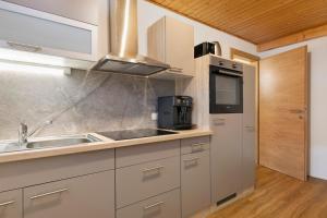 a kitchen with a sink and a microwave at Apartments Winder 3 in Lustenau