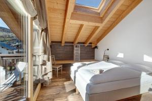 a bedroom with two beds and a large window at Olympic Chalet 13 in Bormio