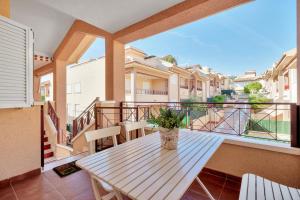 a porch with a wooden table and a balcony at Casa Mario in Puerto Marino