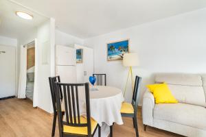 a dining room with a table and a couch at Mon Repaire à Frejus - proche plage in Fréjus +14 photos
