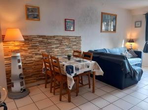 a living room with a table and chairs and a couch at Côte fleurie -Le Cottage D'honfleur in Honfleur