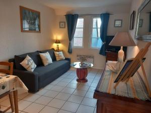 a living room with a couch and a table at Côte fleurie -Le Cottage D'honfleur in Honfleur