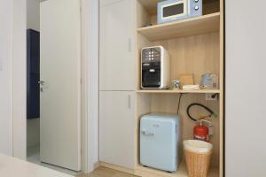 a small blue refrigerator in a kitchen with a microwave at Portofino Garden in Rapallo