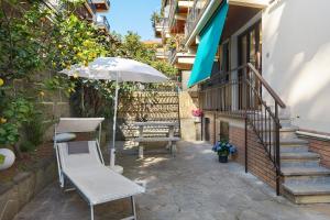 a patio with a chair and an umbrella and stairs at Portofino Garden in Rapallo