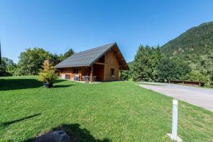 a log cabin on a grass field next to a road at Chalet Arclosan - Val de Tamié in Faverges