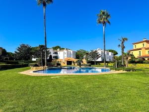 a swimming pool in a yard with palm trees at Port Pals B202 in Pals