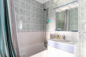 a bathroom with a tub and a sink and a mirror at Charmante Longère La Meslière in Pannecé +15 photos