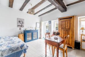 a bedroom with a bed and a table and chairs at Charmante Longère La Meslière in Pannecé