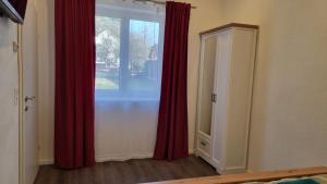 a bedroom with red curtains and a window at Ferienhaus zum Wunschglockerl in Schrems +17 photos