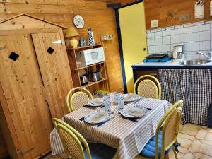 a table in a kitchen with a table and chairs at Maison De Plage La Grise Brèche in Pirou