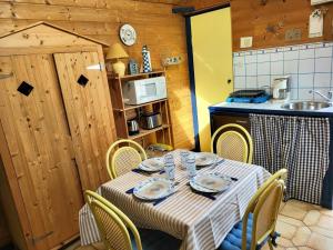 a table in a kitchen with a table and chairs at Maison De Plage La Grise Brèche in Pirou +10 photos