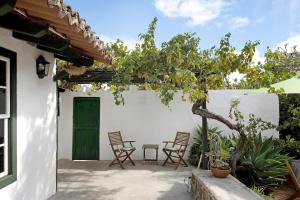 a patio with chairs and a green door at Casa Julia in Las Lagunas