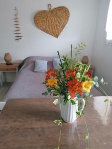 a vase of flowers on a table in a bedroom at Les Alisiers in Eugénie-les-Bains