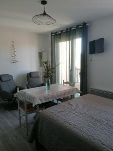 a bedroom with a bed and a table and chairs at Les Alisiers in Eugénie-les-Bains
