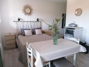a small bedroom with a bed and a table with a tableablish at Les Alisiers in Eugénie-les-Bains