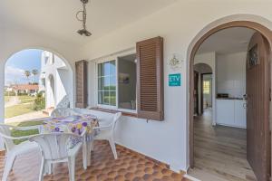 a dining room with a table and chairs and an archway at Giuliana Apartment in Alaior