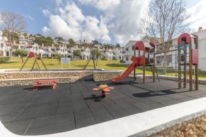 a playground with a red slide and a bench at Giuliana Apartment in Alaior