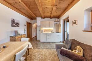 a kitchen and living room with a couch and a table at Eichernhof Apartment Kirschblüte in Verano
