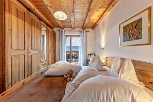 two beds in a room with a clock on the ceiling at Eichernhof Apartment Kirschblüte in Verano